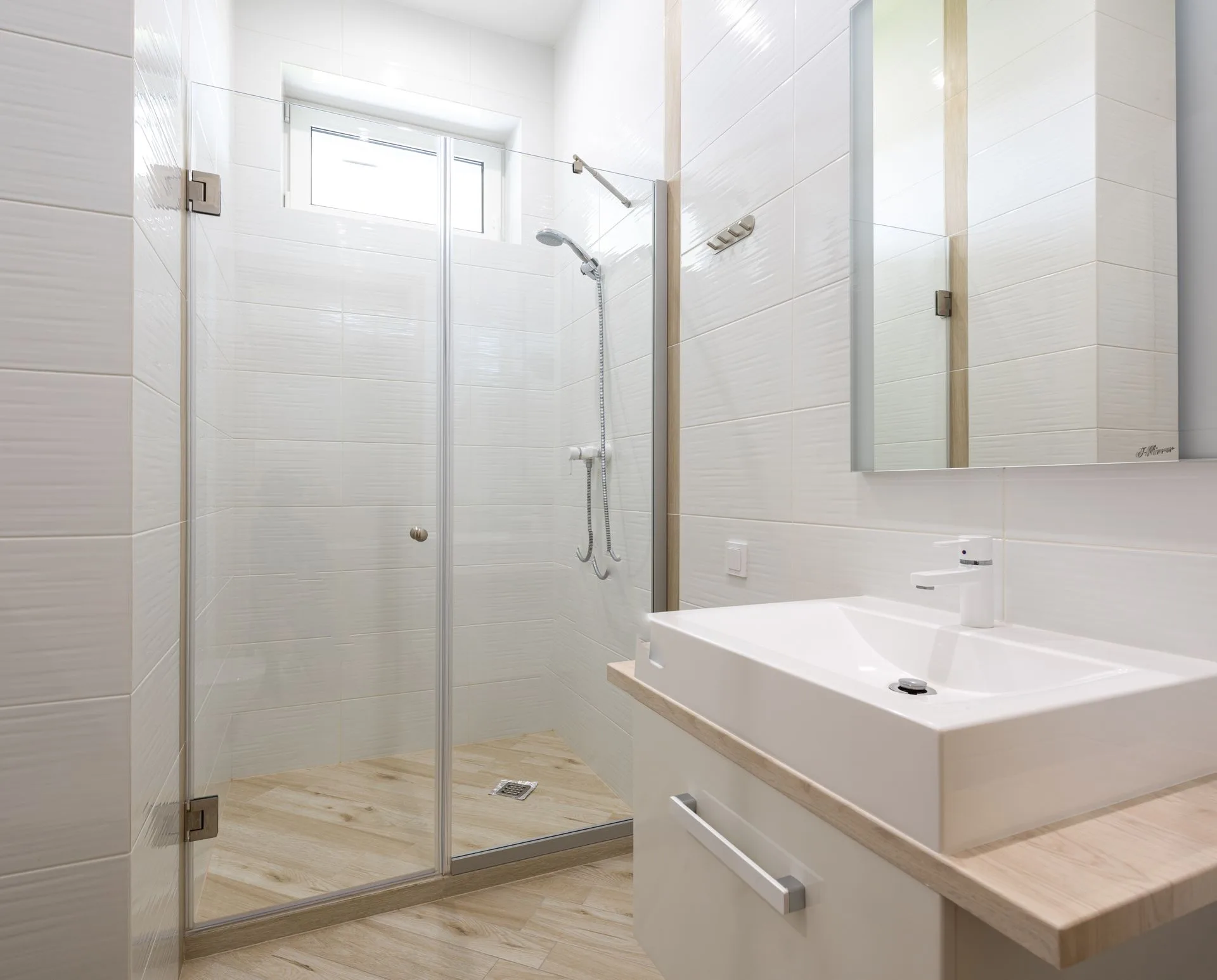 White bathroom with acrylic shower cabin and glass door