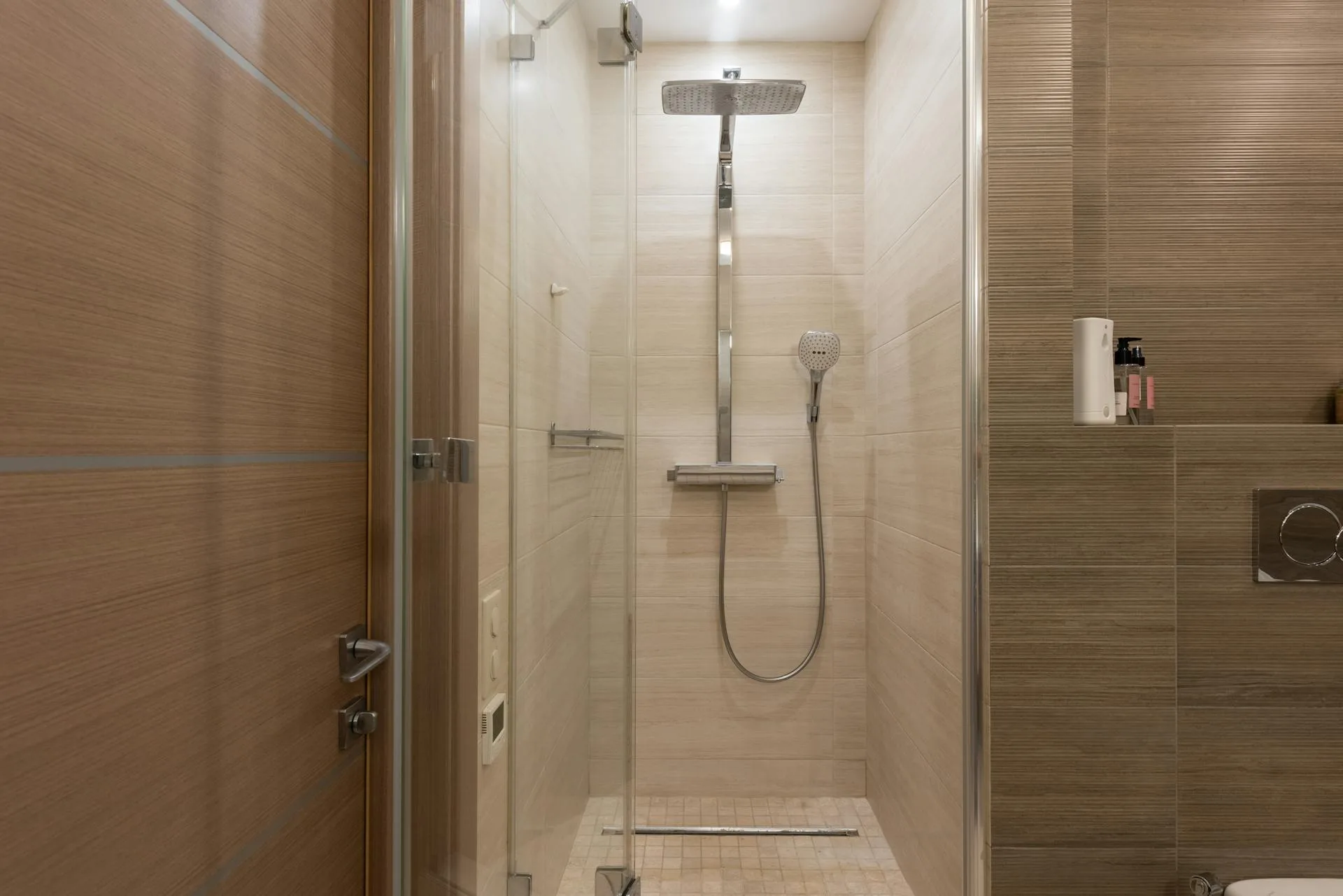 Modern shower cubicle in warm toned bathroom